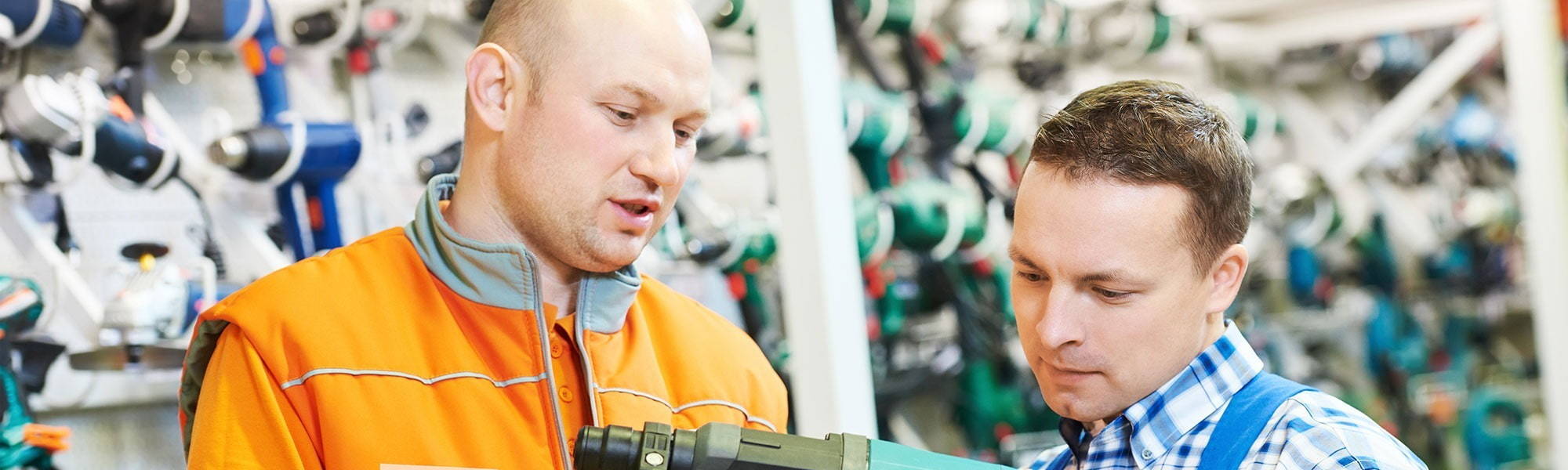 two men at plant and tool hire depot looking at power tools in branch